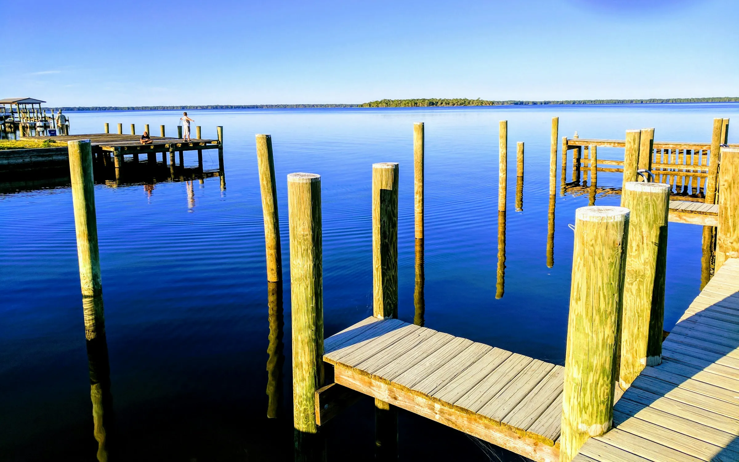 New wooden dock with freshly set pilings and decking over blue water