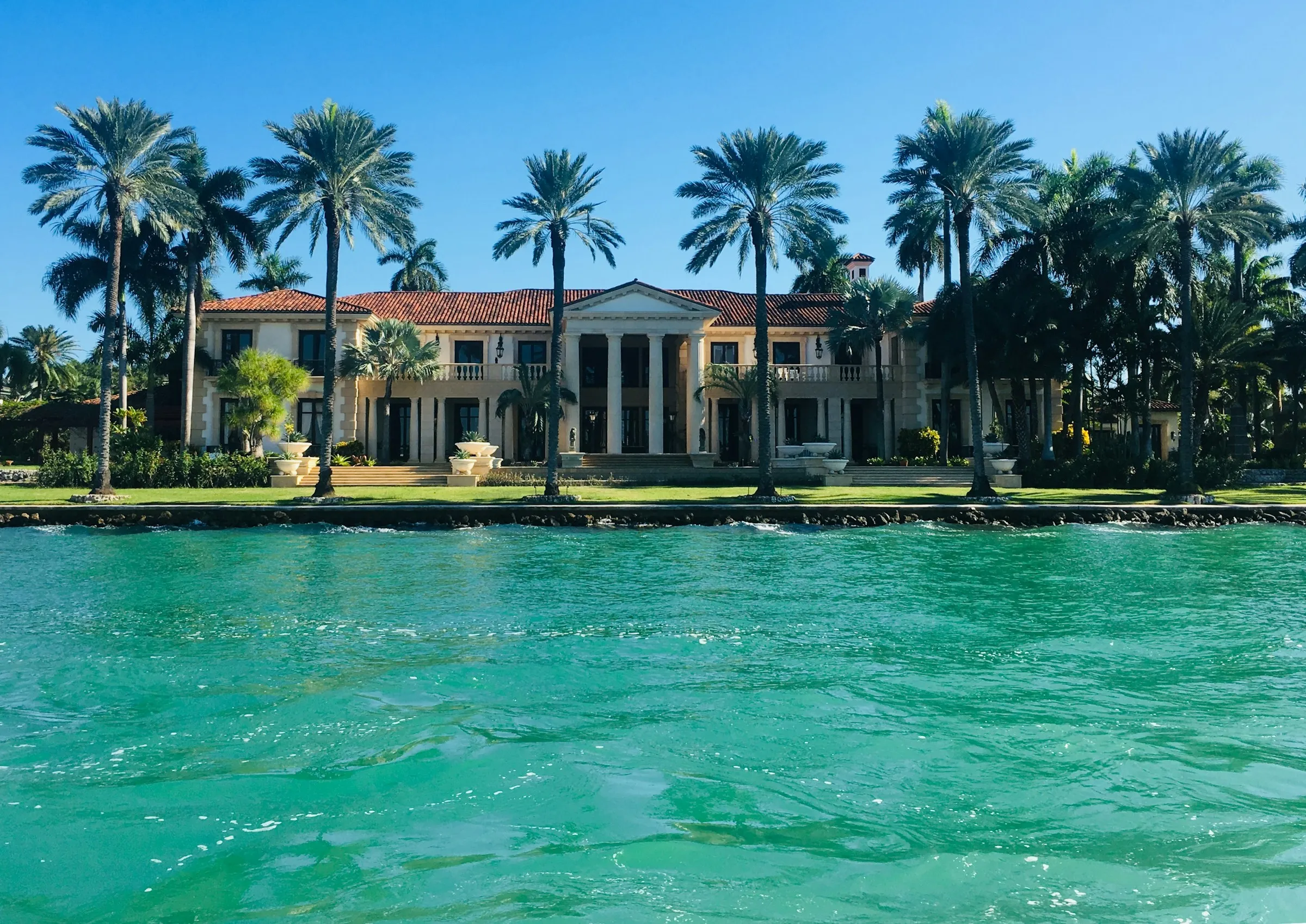 Waterfront home viewed from the water showing its concrete seawall and dock